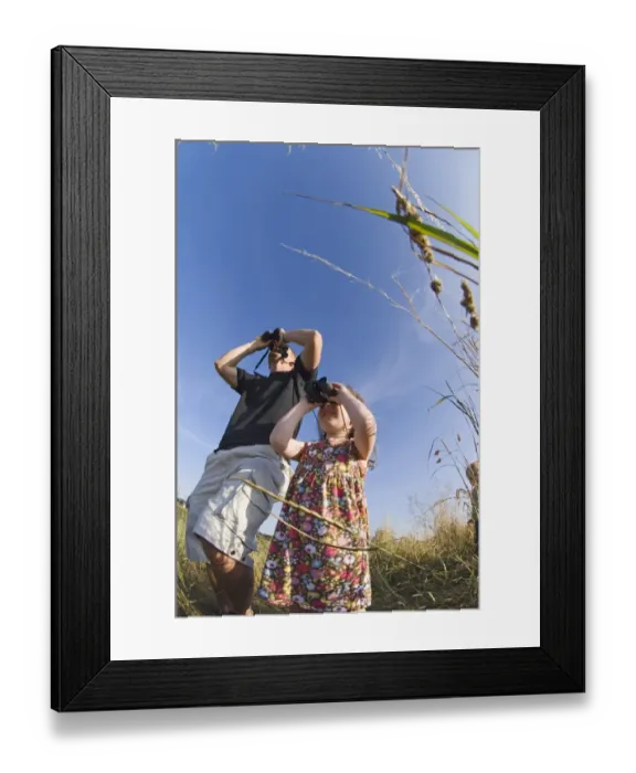 Framed Print : Father and daughter birdwatching at Cley North Norfolk August Framed Print : Father and daughter birdwatching at Cley North Norfolk August