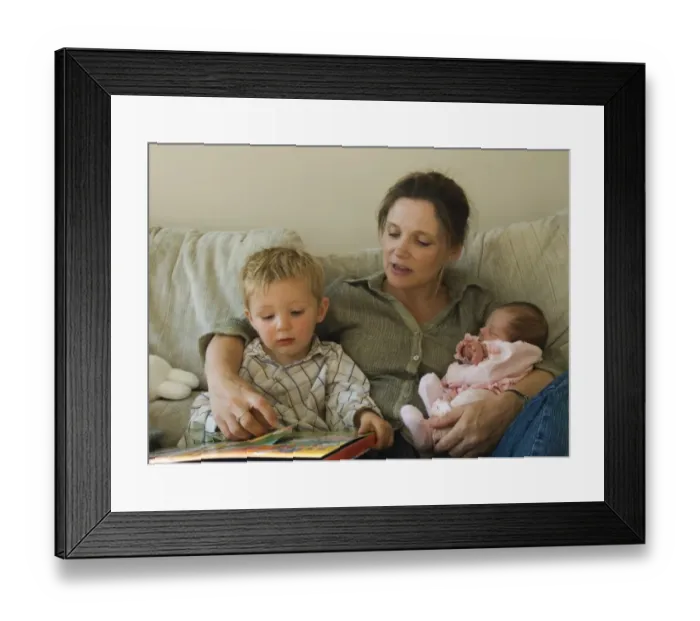 Framed Print : Mother, toddler and new born girl reading childrens book on sofa at home Norfolk UK Framed Print : Mother, toddler and new born girl reading childrens book on sofa at home Norfolk UK