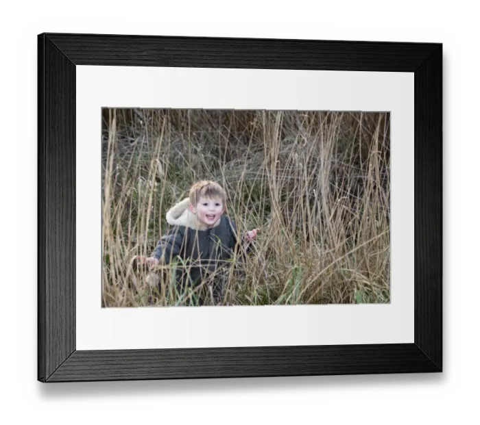 Framed Print : young boy playing hide and seek in reeds Norfolk winter Framed Print : young boy playing hide and seek in reeds Norfolk winter