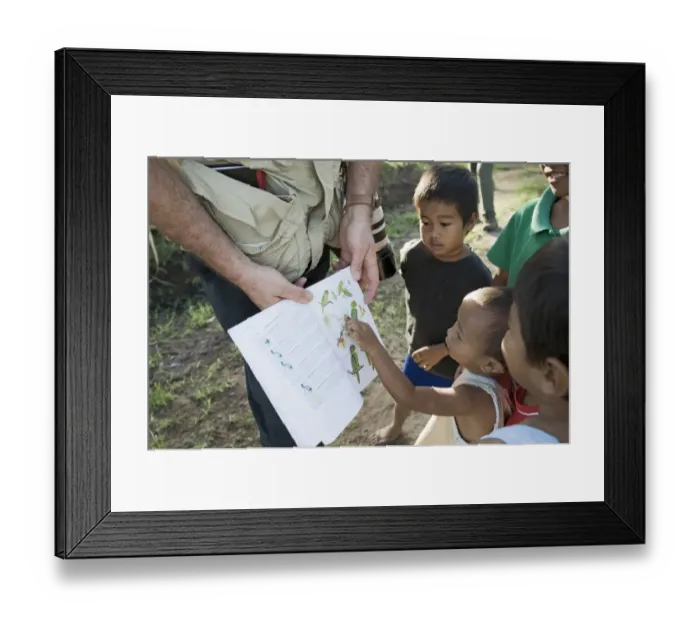 Framed Print : Tim Appleton showing local boys bird illustrations in a field guide at Narra on Palawan Framed Print : Tim Appleton showing local boys bird illustrations in a field guide at Narra on Palawan