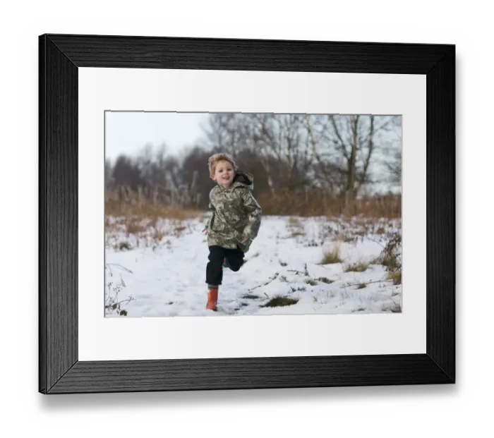 Framed Print : Young boy running through snow Norfolk winter Framed Print : Young boy running through snow Norfolk winter