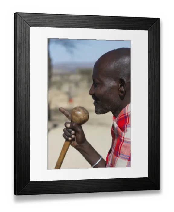 Framed Print : Masai elder holding a Rungu a club used for throwing to ward off hyenas and other Framed Print : Masai elder holding a Rungu a club used for throwing to ward off hyenas and other