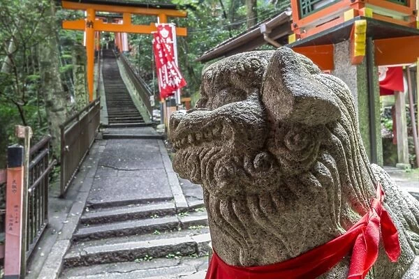 Stone sculpture, Fushimi Inari Taisha, Shinto shrine and vermilion torii gates in wooded forest