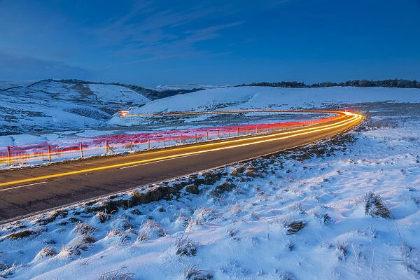 View of trail lights on frozen landscape near Buxton at dusk, High Peak, Derbyshire