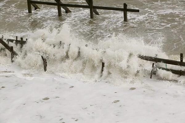 Waves crashing against the sea defences at Happisburgh on the Norfolk Coast. This section of caost is the fastest eroding point in the uK and speeding up to to global warming induced sea level rise and increased stormy