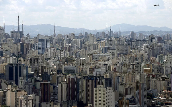 A helicopter flies over the skyline of Sao Paulo