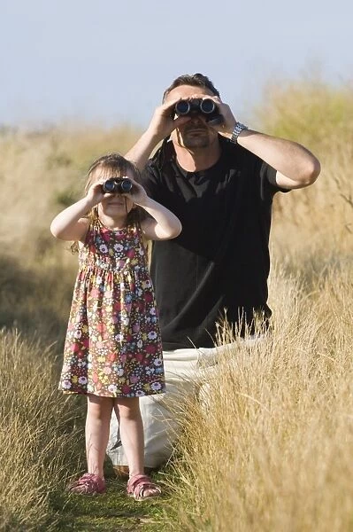 Father and daughter birdwatching at Cley North Norfolk August