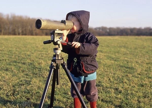 Fledgling birder looking through scope Kent winter