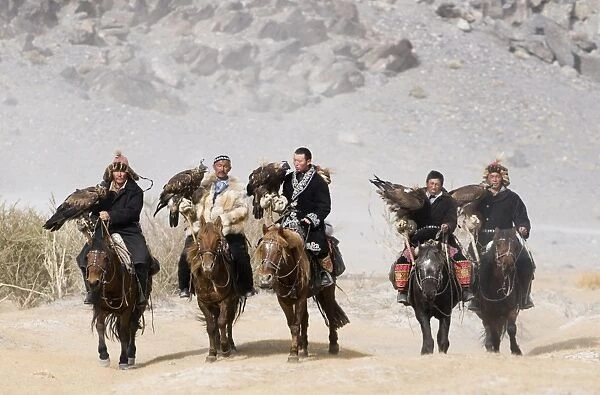 Kazakh eagle hunters with Golden Eagles on way to the Eagle Hunters Festival in