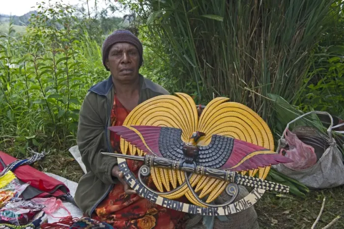 Framed Print : Lady selling wooden carved plaque of Papua New Guinea in design of national emblem Framed Print : Lady selling wooden carved plaque of Papua New Guinea in design of national emblem