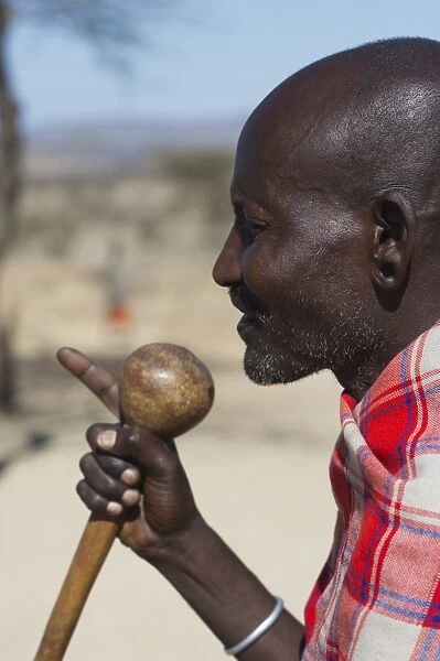 Masai elder holding a Rungu a club used for throwing to ward off hyenas and other