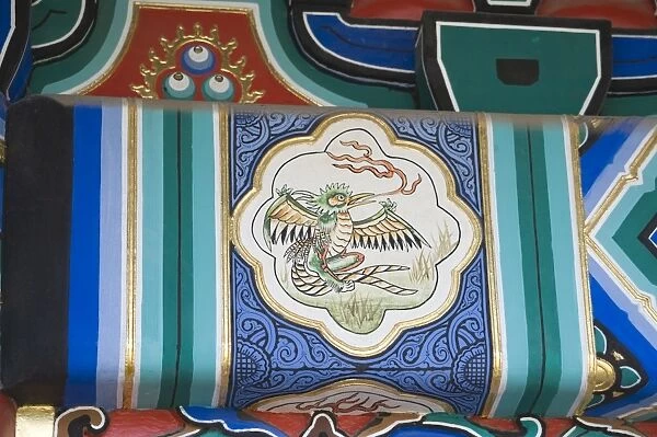 Representation of a Phoenix painted on side of wooden framework below roof of building