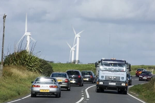 Wind turbines and cars along road near Goonhilly Down Cornwall summer