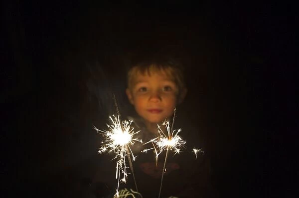 Young boy with sparkler on bonfire night November 5th Norfolk