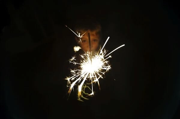 Young boy with sparkler on bonfire night November 5th Norfolk