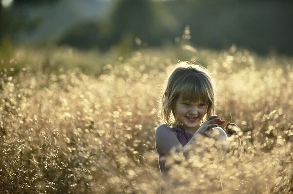 Young girl playing in meadow in late summer Norfolk - Model Released