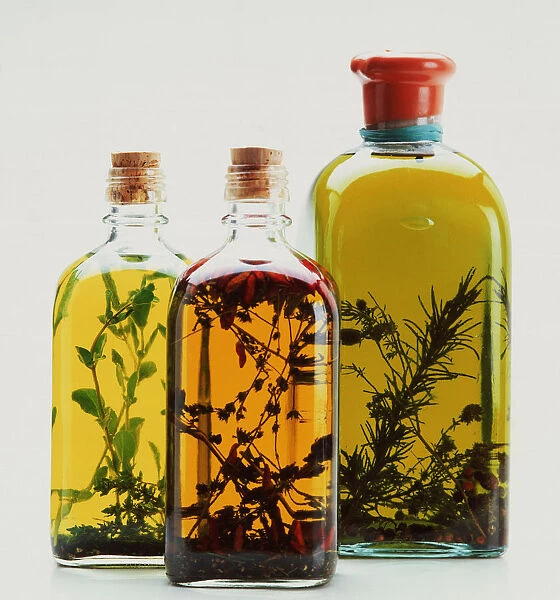 Three bottles of olive oil infused with herbs and spices