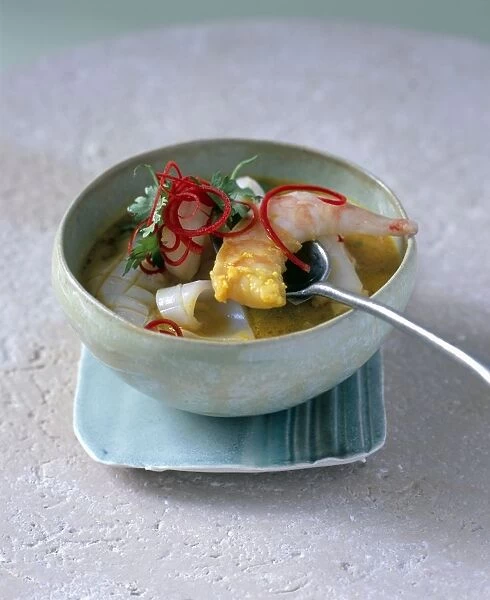 Moily haldi, Sri Lankan coconut and turmeric fish soup, containing prawns, squid and white-fleshed fish, garnished with red chilli and coriander