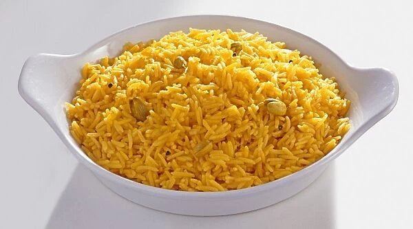 Saffron basmati rice with cardamom pods in serving dish, close-up