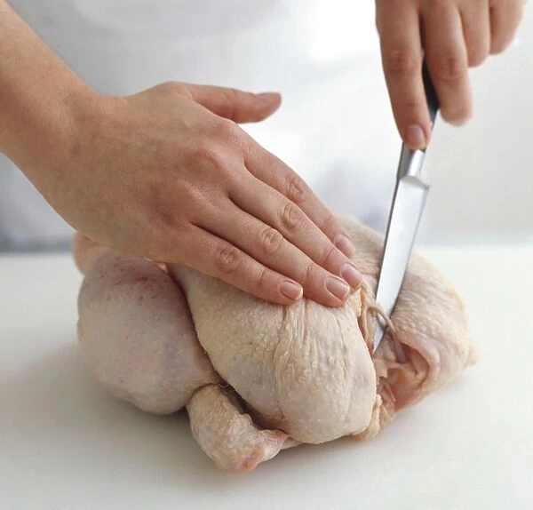 Using sharp knife to expose wishbone of chicken, close-up