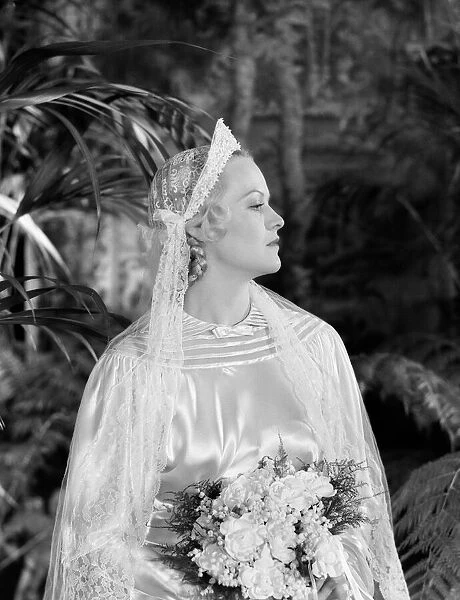 Bride wearing tiara, veil and silk wedding dress, holding bridal bouquet