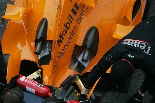 Formula One Testing: McLaren mechanics have to use fire extinguishers on the exhausts of Kimi Raikkonen McLaren Mercedes MP4  /  21