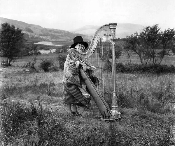 A Harpist wearing traditional Welsh National dress. Circa 1920