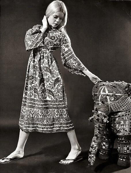 A model wearing a swirly print midi dress with wide bell sleeves made from Indian cotton