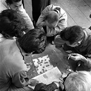 Men smoke and play a game of checkers in Canton, China