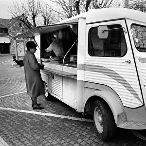 A woman buys meat from a mobile shop in Neuville Sur Oise
