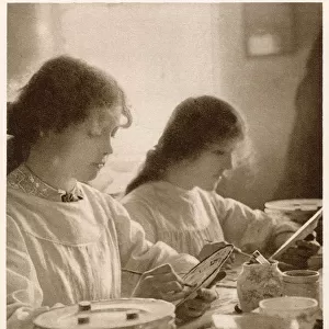 Young women painting plates, this would of been done in several stages. Date: 1913
