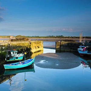 England, Northumberland, Beadnell. Boats moored within the Harbour Walls of the Beadnell Harbour - viewed at