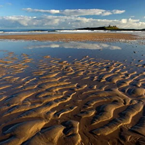 View across Embleton Bay at low tide towards the ruins of Dunstanburgh Castle