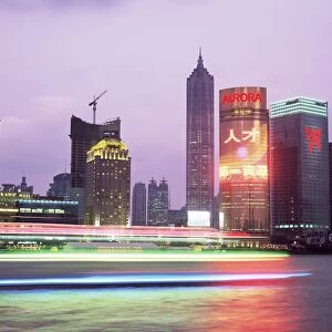 View across river at dusk to the new Pudong district skyline, Huangpu River