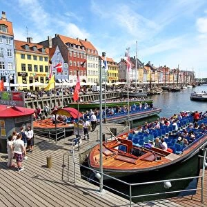 Coloured houses and tourist sightseeing tour boats at Nyhavn Quay in Copenhagen, Denmark