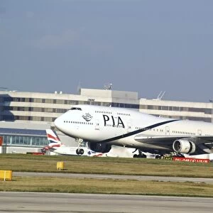 pia;747;landing;airport terminal inbackground;bright sunny day;manchester
