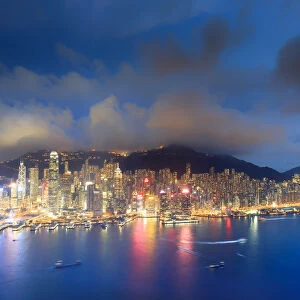 Hong Kong, city overview by night with Victoria harbour and peak in the background
