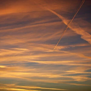 Contrails from a passenger plane is seen during the sunset in Berlin