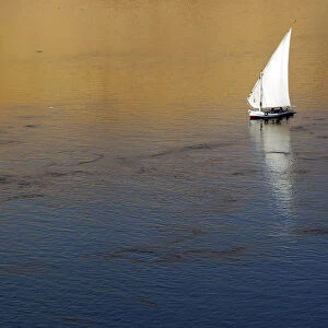 Traditional Egyptian Felucca boat sails on the Nile river in the southern Egyptian
