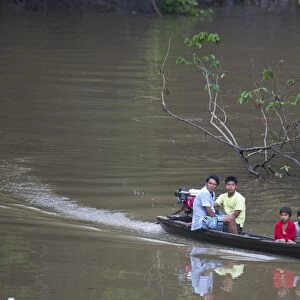 Family on tributary of River Amazon Nr Iquitos Peru