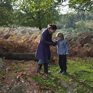 Mother and son in woodland in autumn Kent UK