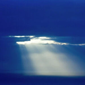 Sun poking through clouds at dusk over North Sea Shetland