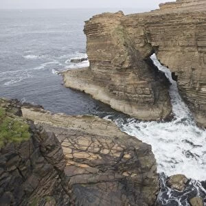 View of sea cliffs with water flowing through sea arch, Yesnaby, Mainland, Orkney, Scotland, june