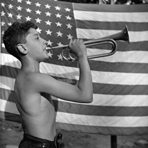 BUGLER, 1943. A camper playing mess call on a bugle at Camp Nathan Hale, an interracial