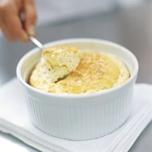 Cheese souffle being spooned out of dish, close up