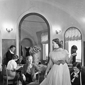 A woman trying on a dress at a tailoring shop in moscow, november 1955