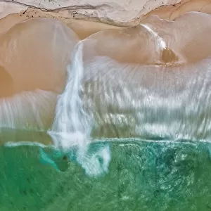 Aerial view of turquoise water crashing onto a sandy beach - Long Exposure