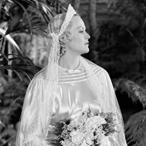 Bride wearing tiara, veil and silk wedding dress, holding bridal bouquet