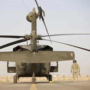 Crew Chiefs stand beside their UH-60L Black Hawk helicopter