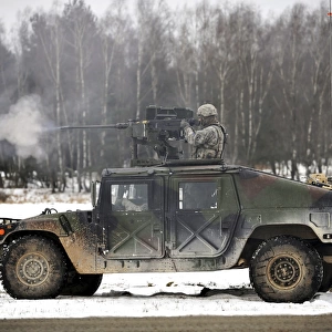 U. S. Army paratrooper fires an M2. 50-caliber machine gun atop a humvee